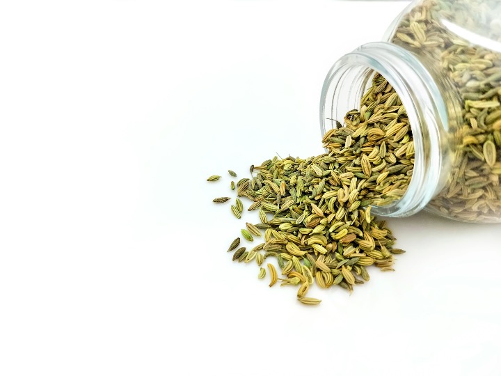 a glass jar filled with seeds on top of a white table